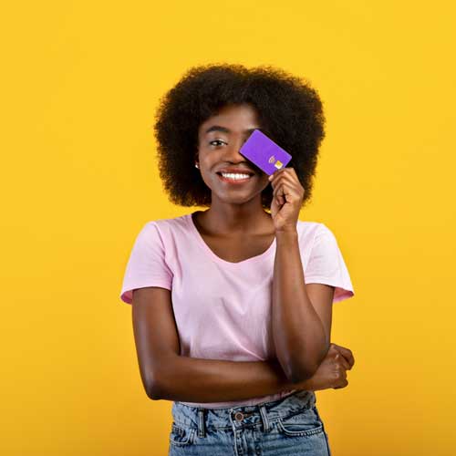 A lady holds her credit card to cover her left eye