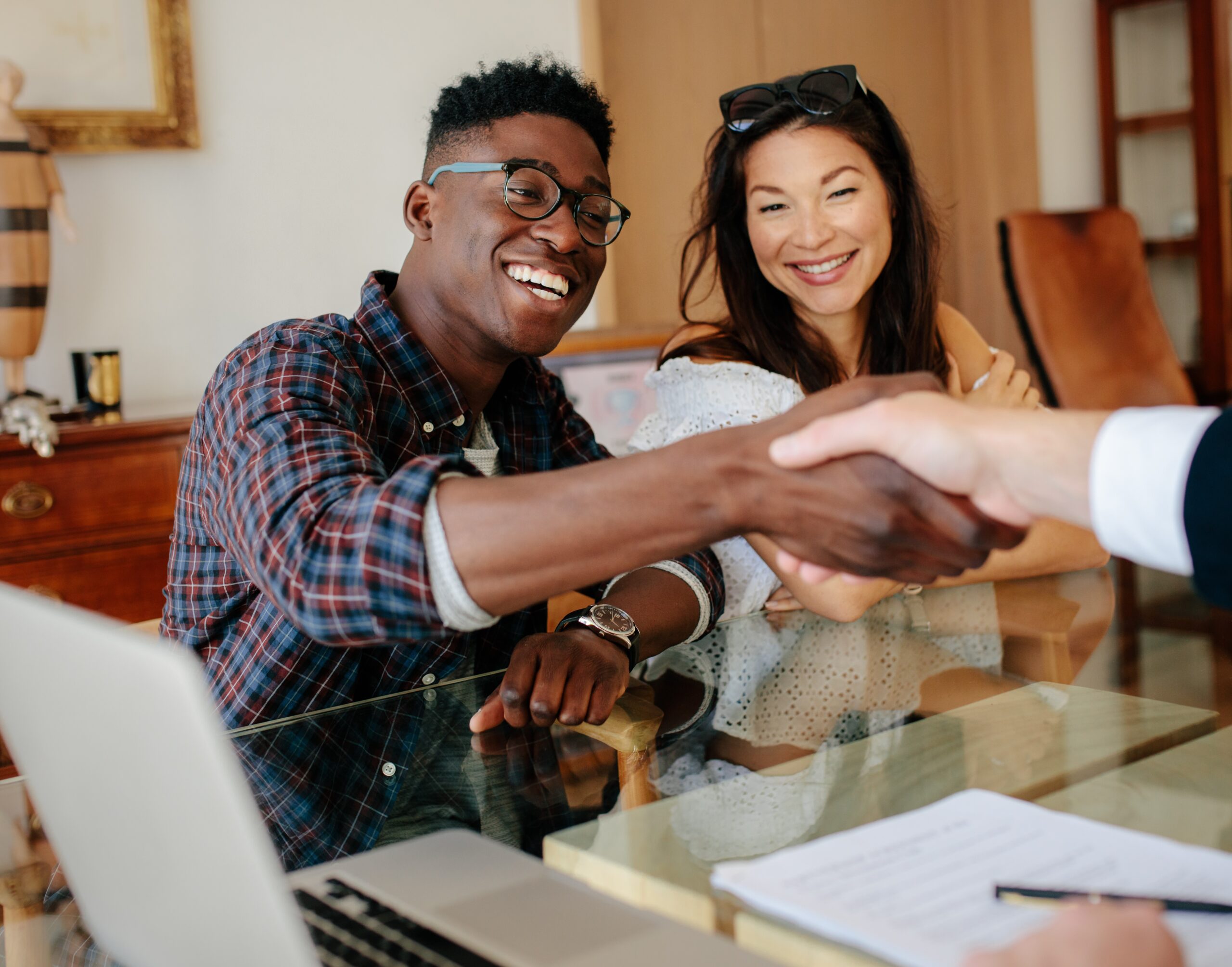 Couple handshaking realtor after signing contract